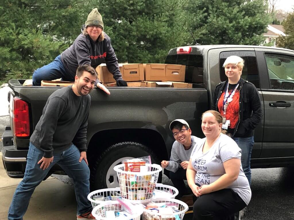 Three Rivers Community College students Cody Sowell, Thena Cranfill, Joe Victorino, Marie Parry and Samantha Bartosiak load a pick-up truck with turkeys and Thanksgiving fixings to bring to the Norwich Vet Center. 