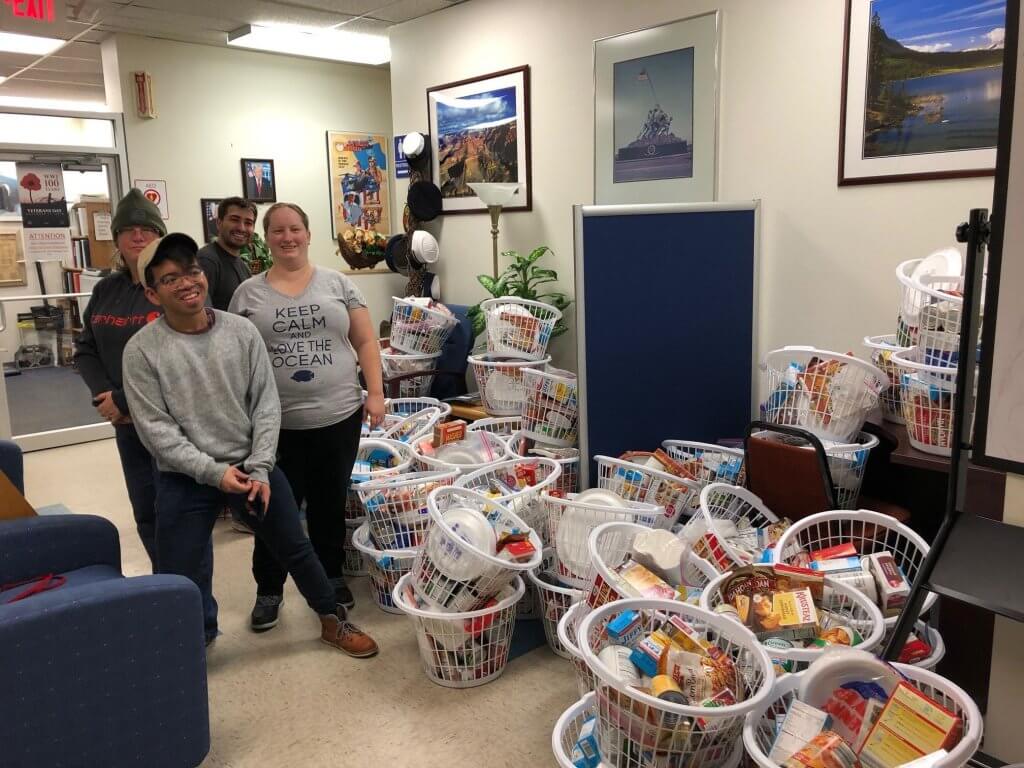 (Left to right) Three Rivers Community College students Thena Cranfill, Joe Victorino, Cody Sowell, and Marie Parry pose with some of the 80 Thanksgiving dinners they delivered to the Norwich Vet Center. 