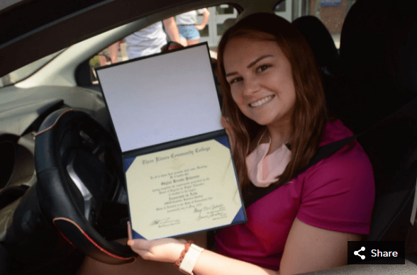 student smiling with degree