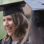 a woman smiling in graduation attire